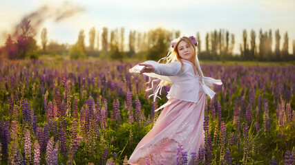 Fototapeta na wymiar Beautiful blonde girl in a fantasy outfit dress on a field of lupines flowers at sunset in backlight.girl spring hello summer. Magical Photos, Korean Style Clothes. 