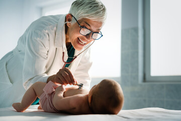 Pediatrician examining little baby to prevent diseases