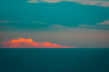 Red cloud fallen over the sea. Scenic view of the sky and the sea, abstract
