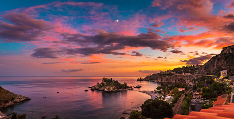 Panoramic view of a magical sunset sky over the beautiful Isola Bella beach in Taormina, Sicily