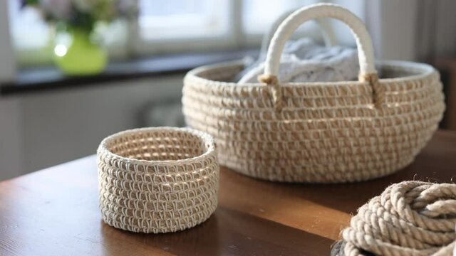 Handmade home decor made from organic jute fiber. Two wicker jute baskets are placed on a wooden table. jute rope and fiber. the concept of home decor and comfort in the eco style.
