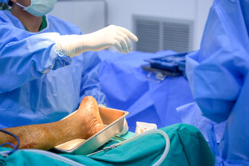 Orthopedic doctor and physician assistant team Use instruments for foot orthopedic surgery in hospital operating room.