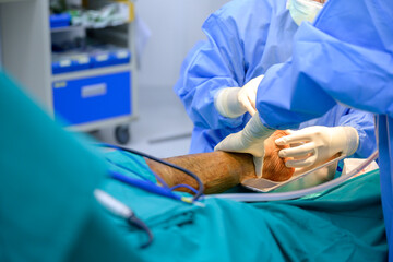 Orthopedic doctor and physician assistant team Use instruments for foot orthopedic surgery in hospital operating room.