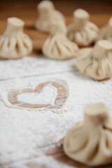 Khinkali in shape of a heart on a wooden table. Valentines Day concept, love for food.