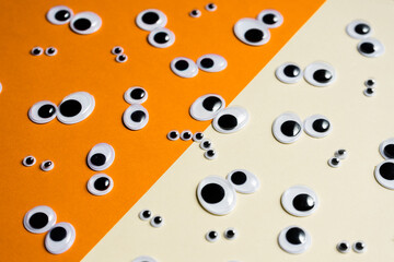 Lots of toy eye emojis on a multi-colored background split in half