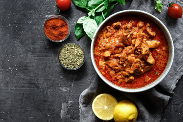 Traditional curry and ingredients. Tikka Masala chicken and rice. Indian food. Top view. Copy space. Dark background.