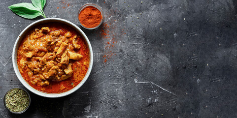 Traditional curry and ingredients. Tikka Masala chicken and rice. Indian food. Top view. Copy space. Dark background.