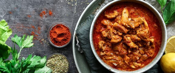 Traditional curry and ingredients. Tikka Masala chicken and rice. Indian food. Top view. Copy space. Dark background.