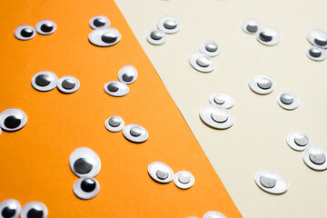 A bunch of toy eyes on an airtight two-color background split in half