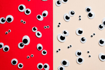 A bunch of toy eyes on an airtight two-color background split in half