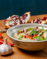 Salad with beef, onion and cilantro in sweet and sour sauce. With pomegranate seeds.