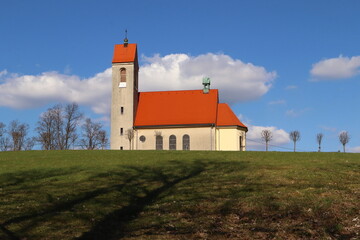 Fototapeta na wymiar Church in the village of Nova Ves. Church with a red roof with a blue sky
