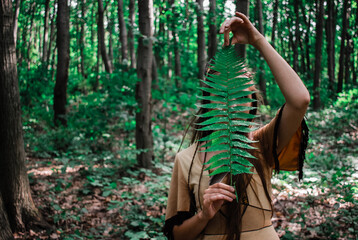 Native american indian shaman holding herbs in the forst, beautiful strong woman promoting...