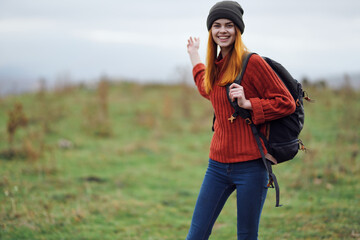 cheerful woman hiker in autumn clothes with a cutter in the mountains landscape on a trip