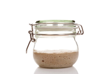 Active sourdough starter in a glass jar for homemade bread.