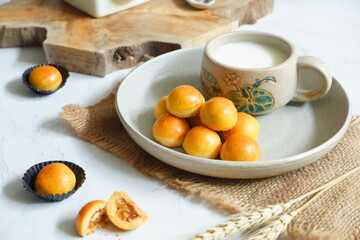 a plate of pineapple tart served with fresh milk on the table