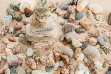 multicolored river pebbles stones randomly lie on the sand next to the sea. Macro photography. Close-up background concept, copy space
