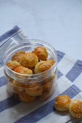 a jar of pineapple tart cookies topped with grated cheese 