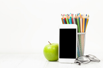 Naklejka premium Workplace with smartphone, supplies and apple