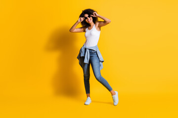 Full length photo of dark skin happy woman wear glasses tight waist jacket isolated on bright yellow color background