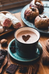 turquoise cup of hot coffee on grey background with cinnamon sticks and christmas decorations