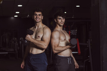 Fototapeta na wymiar two young athletes posing in a gym after doing sports
