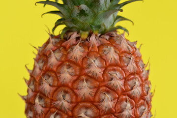 Ripe pineapple on yellow background.