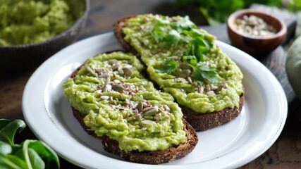 Toast with mashed avocado and seeds on a plate. Healthy vegan vegetarian avocado toasts