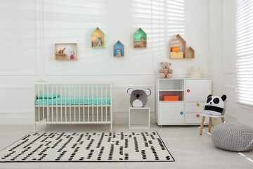 Comfortable crib near wall with color shelves in baby room. Interior design