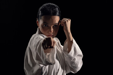Portrait of young woman in kimono in fighting stance looking at camera