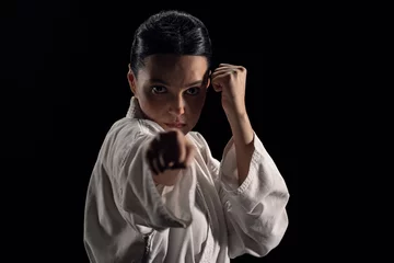 Fotobehang Portrait of young woman in kimono in fighting stance looking at camera © a_medvedkov