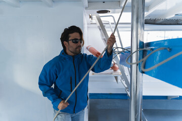 Man holding ropes on a boat