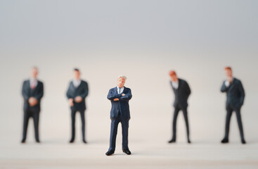 Close-up of miniature figure of one businessman standing out from the crown of others businessmen , Leadership concept.