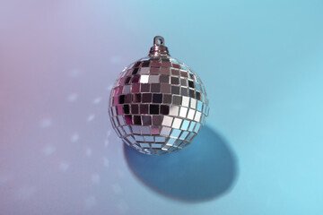 Shiny disco ball on light blue background, above view