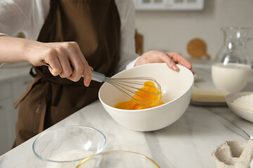 Woman making dough at table in kitchen, closeup