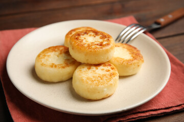 Delicious cottage cheese pancakes on wooden table