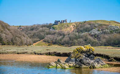 A view across the stream on the beach at Three Cliffs Bay, Gower Peninsula, Swansea, South Wales on a sunny day