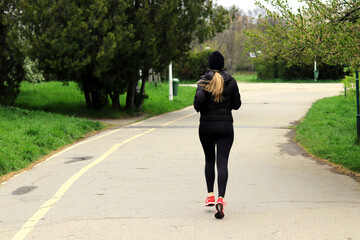 The girl starts jogging in the park.