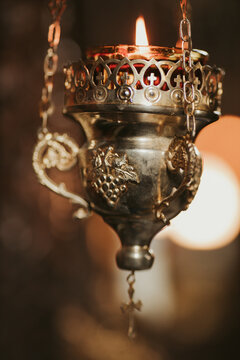 Vertical shot of an antique thurible with fire captured inside a church