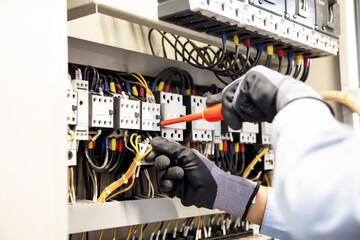 Electricians work to connect electric wires in the system, switchboard, electrical system in Control cabinet.