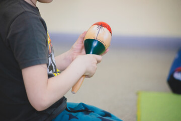 Child holding a musical instrument maracas - Powered by Adobe