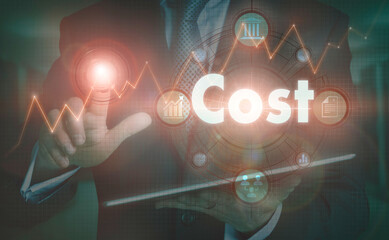 A businessman operating a computer display with a Cost business word concept on it.