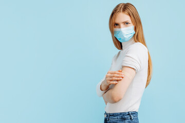 young woman in mask vaccinated, immunity, blue background, recommended vaccination, vaccination