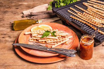 Grilled scorzonera with sauce on old wooden table