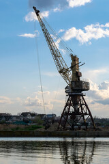 An old harbor crane is waiting for the ship.