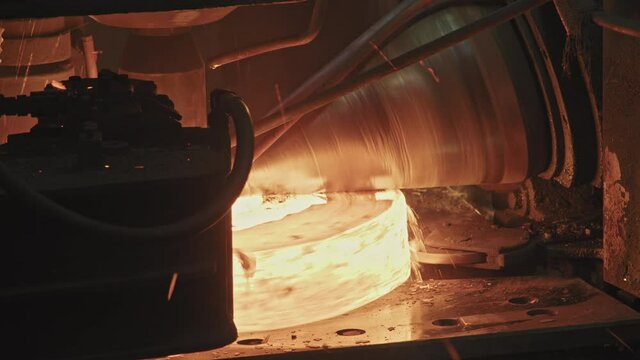 Close up of ring rolling machine forging steel rings red from heat and temperature in forging shop
