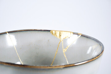 Grey broken pottery restored with Kintsugi, representation of broken heart with pottery.