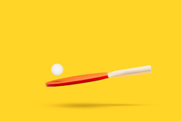 Raqueta de ping-pong con una pelota levitando sobre un fondo amarillo liso y aislado. Vista de...