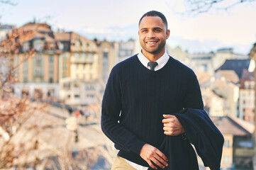 Outdoor portrait of handsome afro american man, city landscape on background