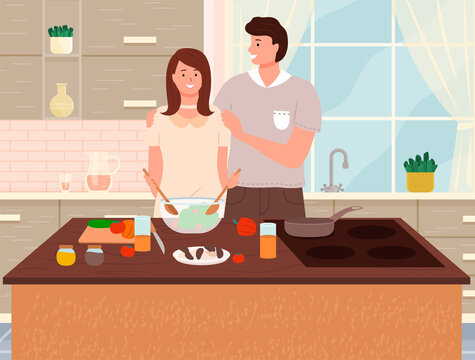 Happy family cooking healthy vegetarian food together in kitchen at table. Prepearing family dinner in cook room interior. Young couple make salad, woman cuts vegetables for useful eating home food